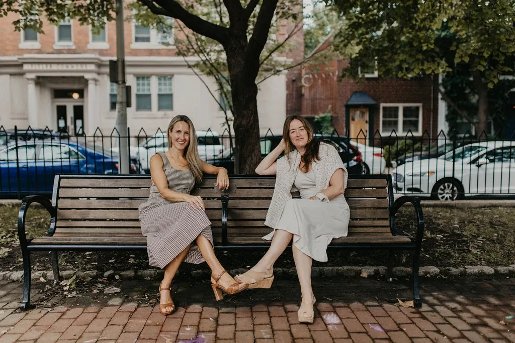 Liz Stokes and Nancy Murphy, co-founders of Care Collaborative, sitting on a park bench in Philadelphia